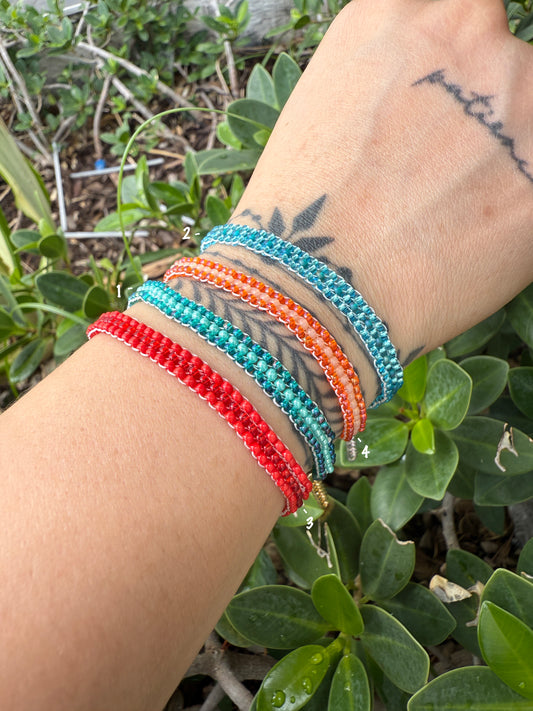 Wrist with colorful beaded bracelets against a natural background