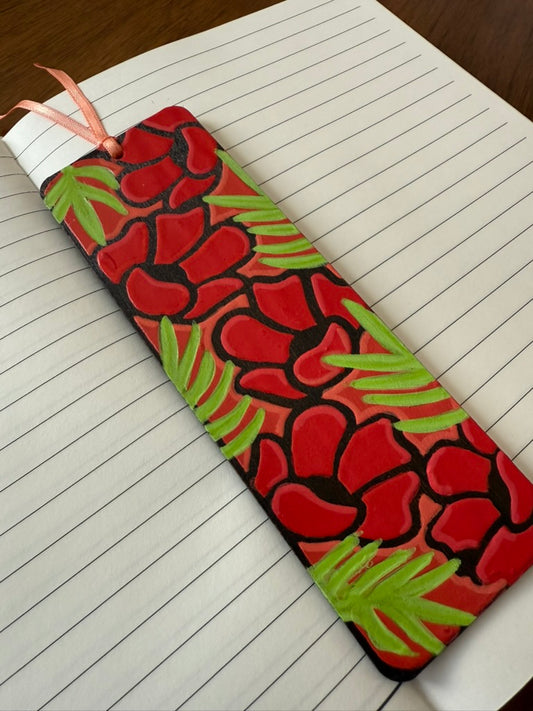 Decorative bookmark with red floral pattern on a notebook page