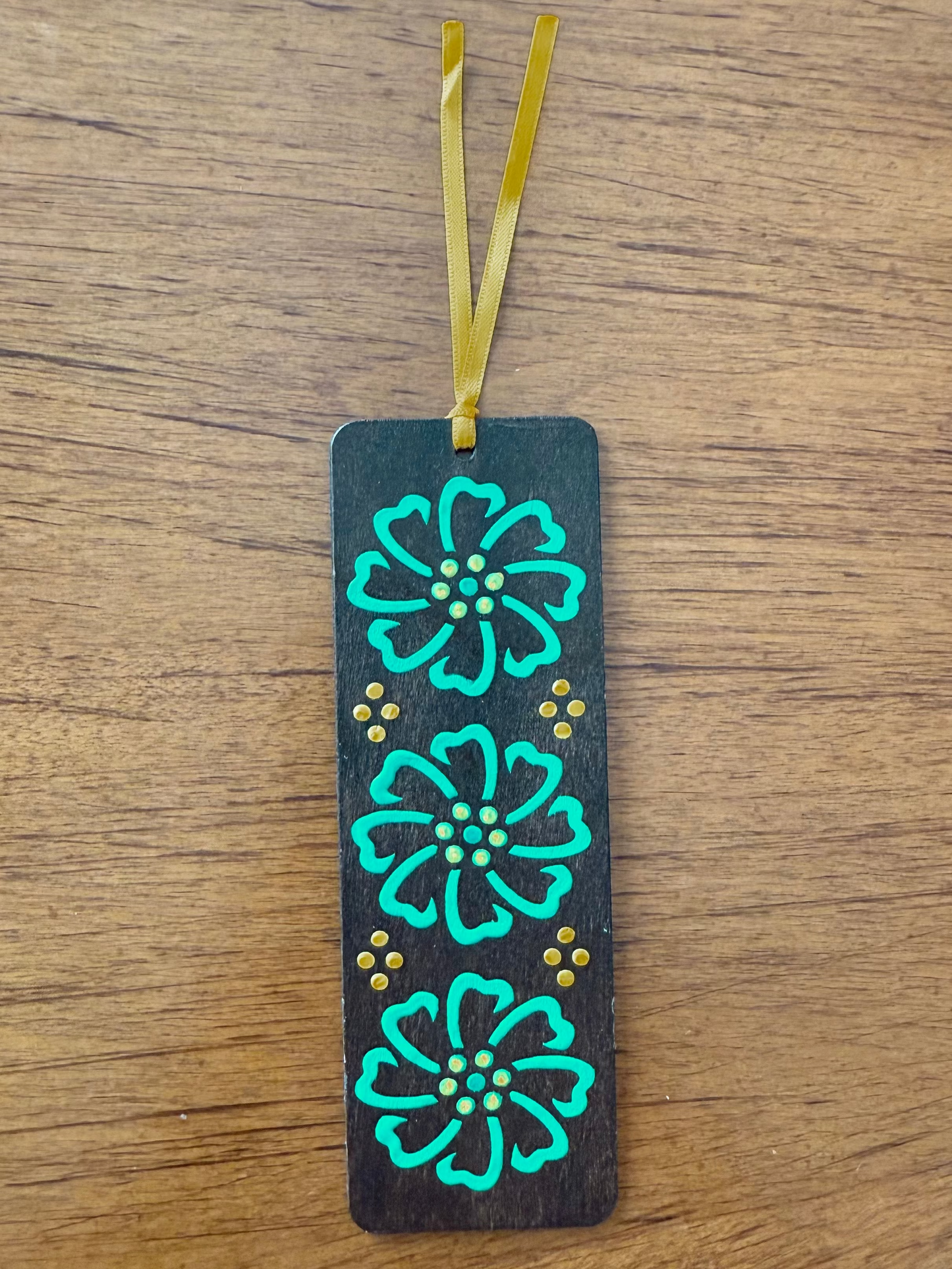 Bookmark with floral designs on a wooden surface