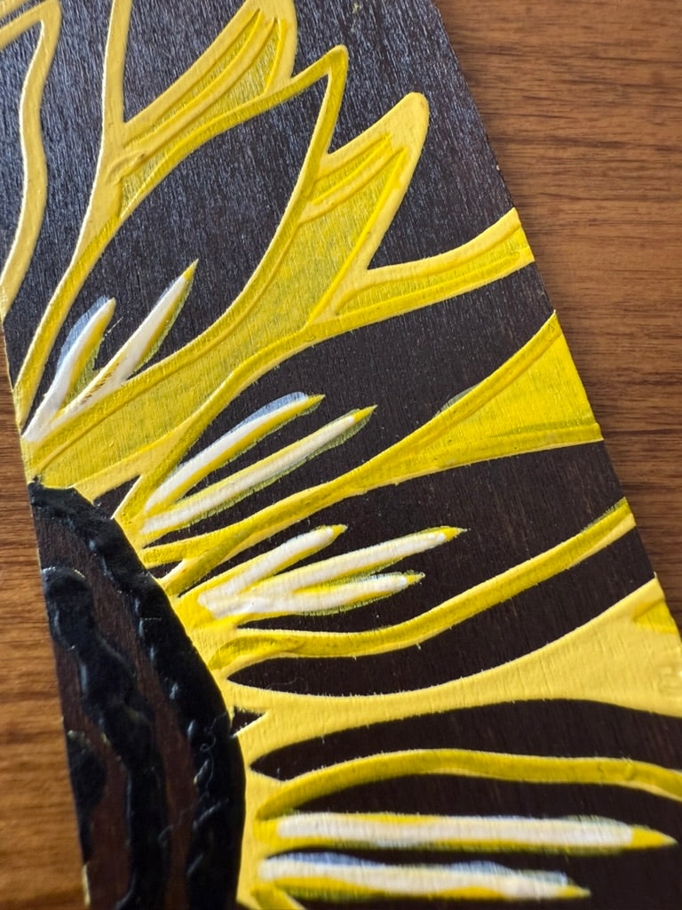Close-up of a black and yellow patterned object on a wooden surface