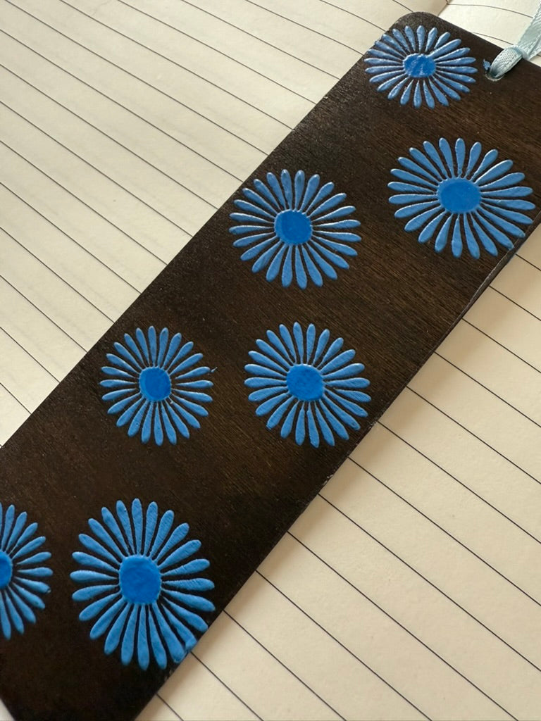 wooden bookmark with blue floral patterns on a wooden surface