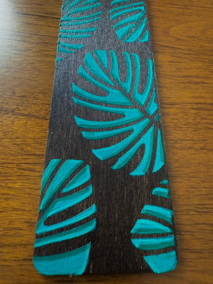 Teal leaf patterned object on a wooden surface