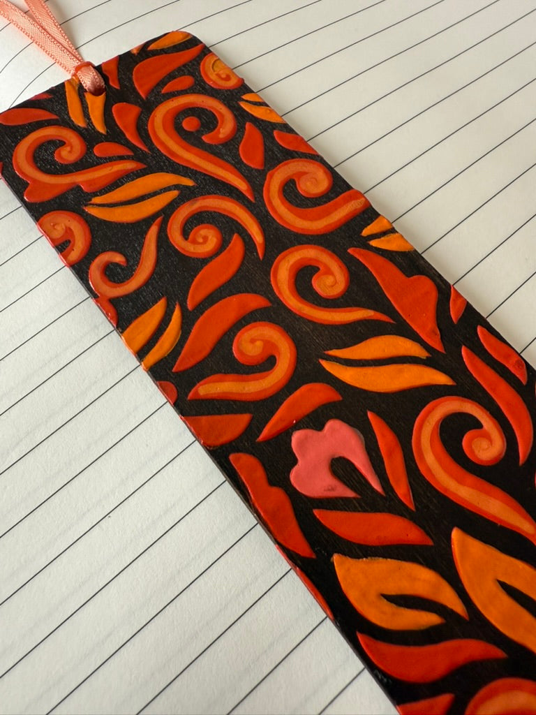 bookmark with orange and red patterns on a wooden floor
