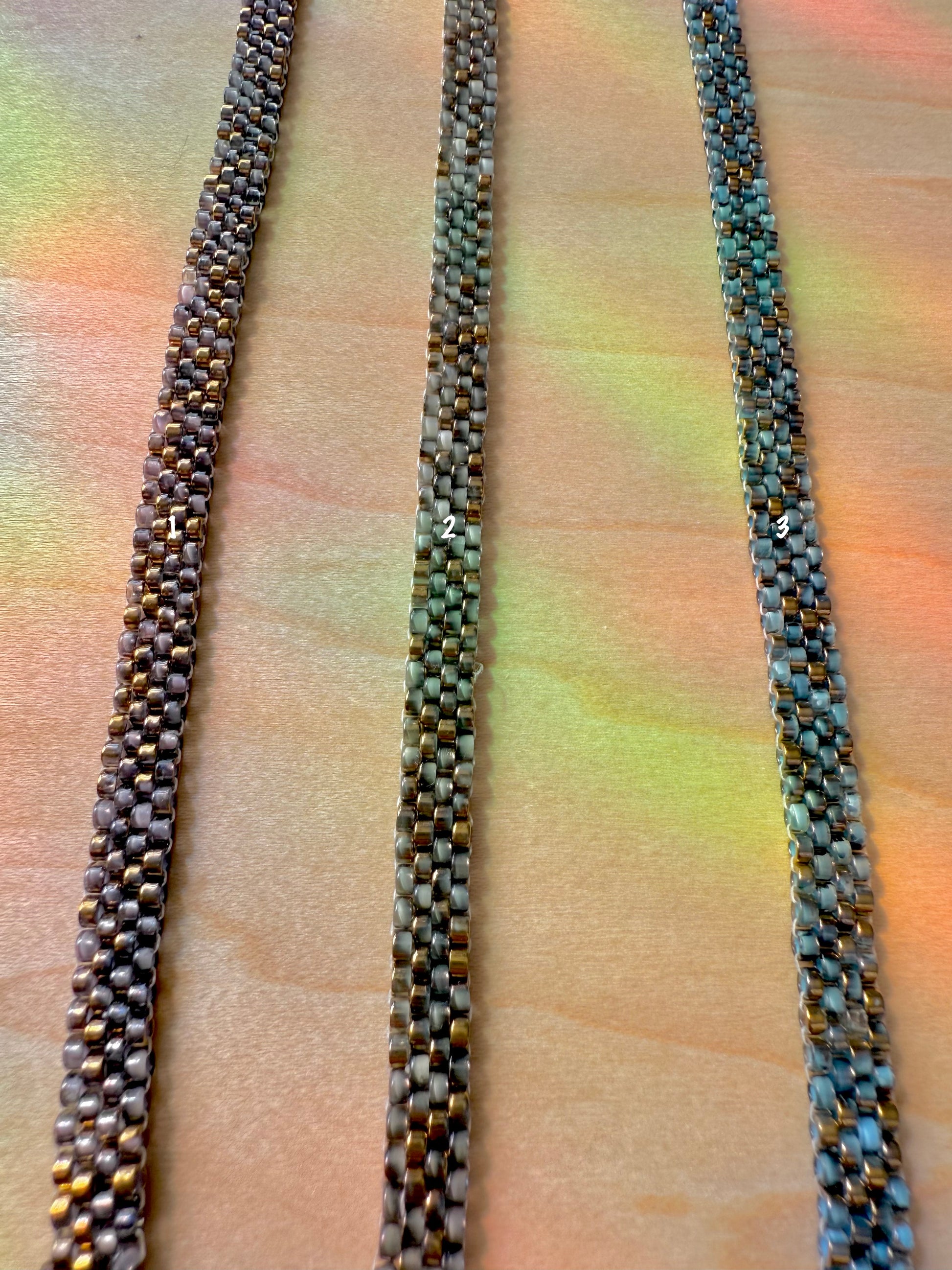 Three woven ropes of different colors on a textured surface