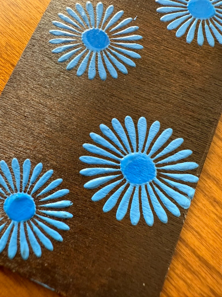 wooden bookmark with blue floral patterns on a wooden surface