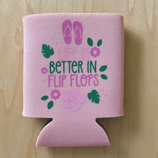 Pink can cooler with flip flop design and text on a wooden surface