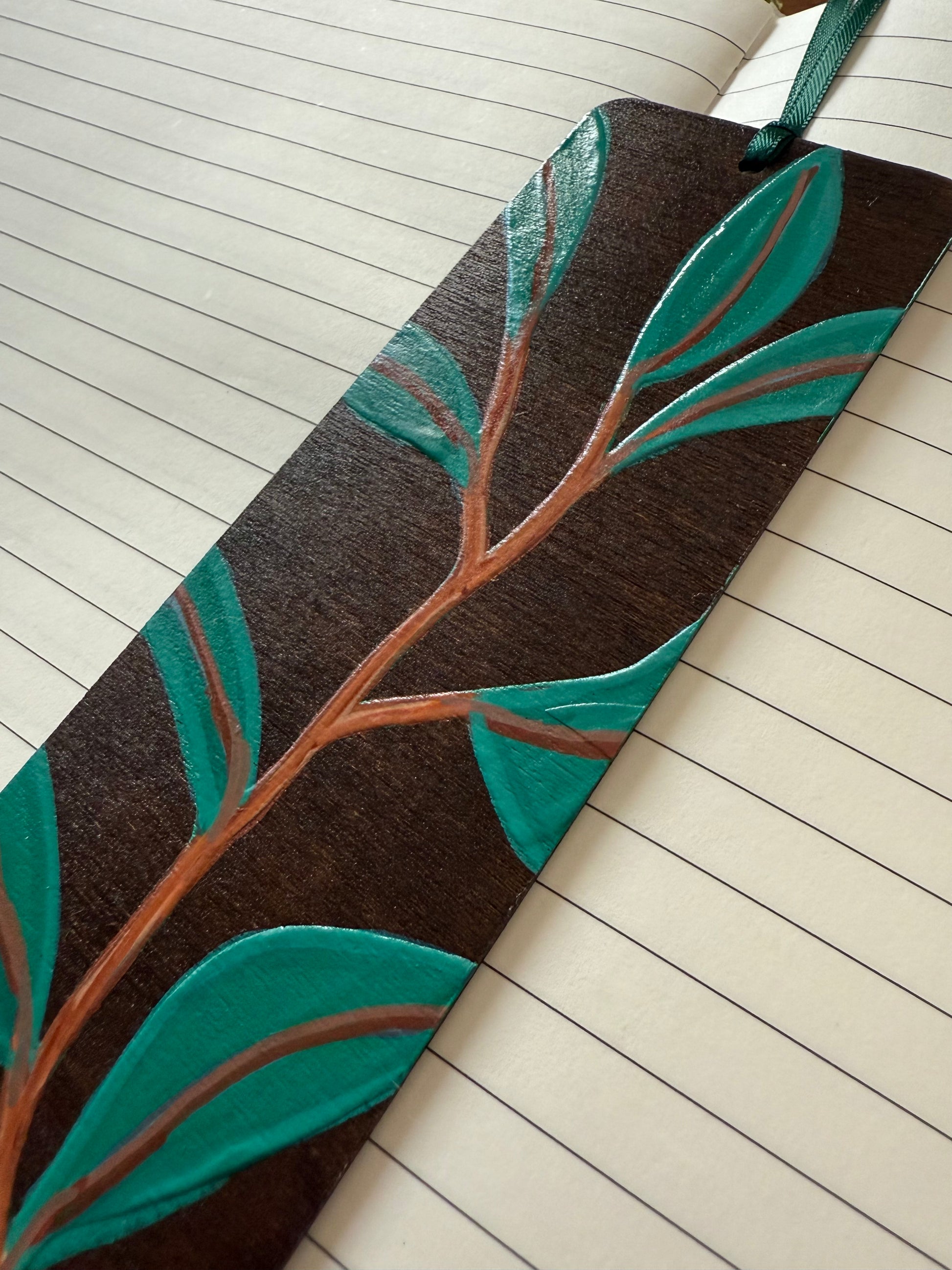Wooden bookmark with leaf design on lined notebook pages