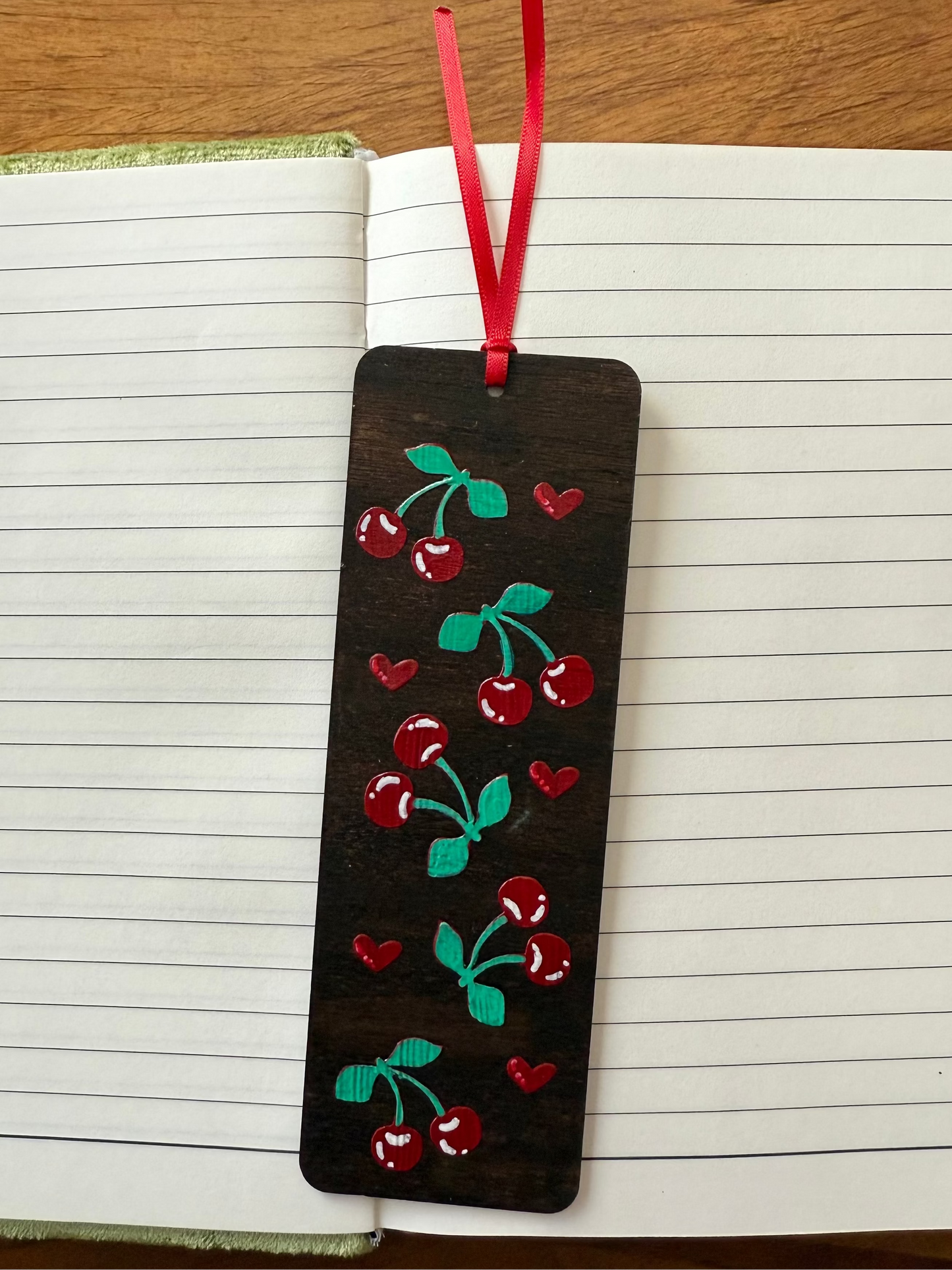 Decorative bookmark with cherry design on a notebook page
