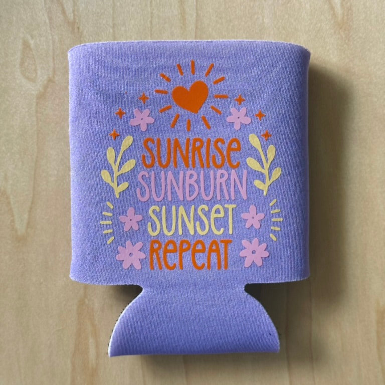 Purple can cooler with 'Sunrise Sunburn Sunset Repeat' text on a wooden surface