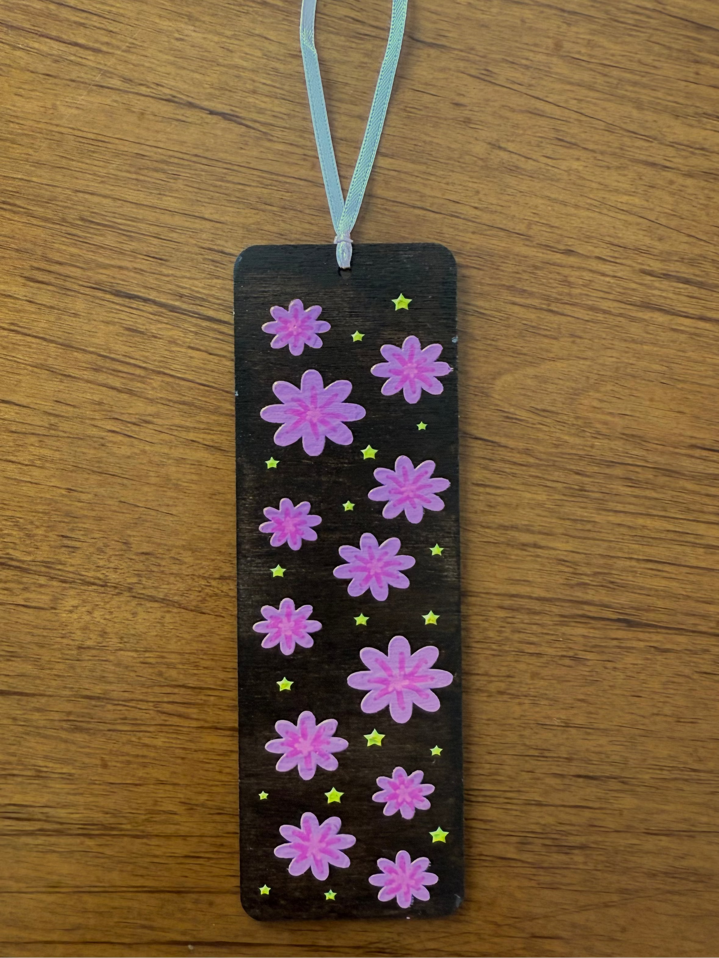 Bookmark with pink flowers on a wooden surface