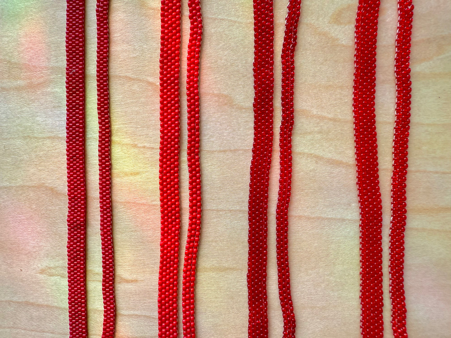 Close-up of red beaded strings on a textured beige background