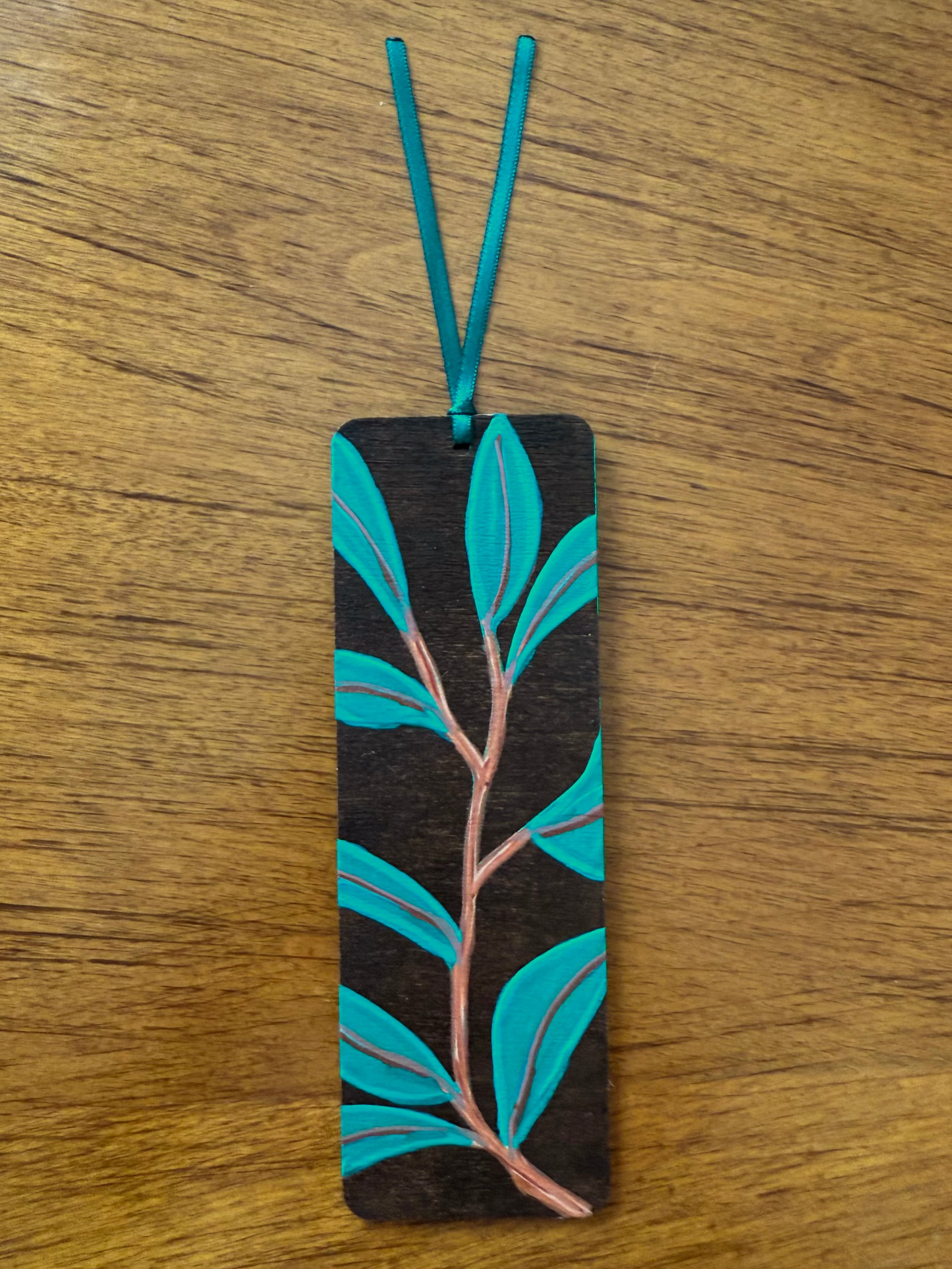 Bookmark with leaf design on a wooden surface