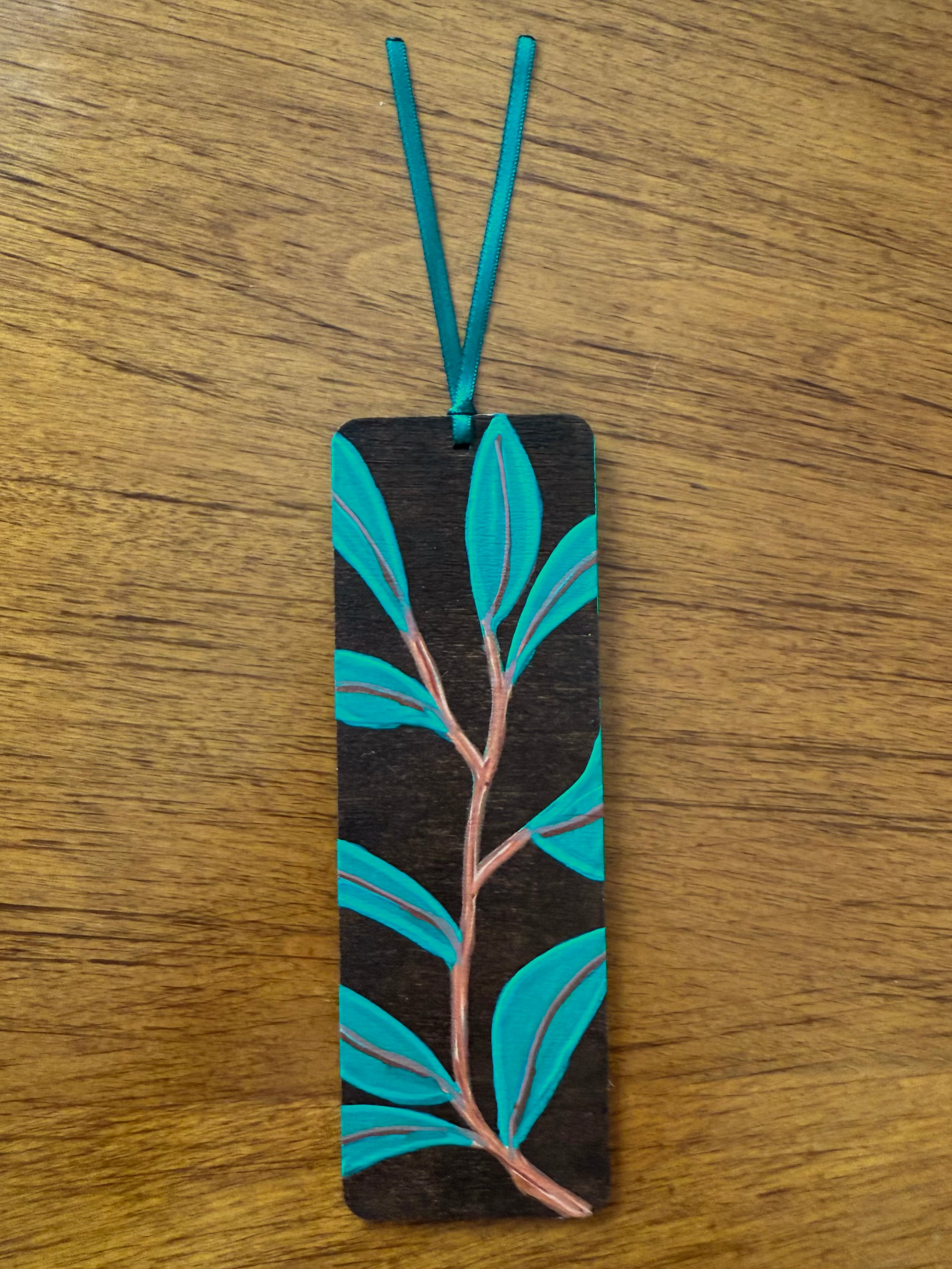 Bookmark with leaf design on a wooden surface