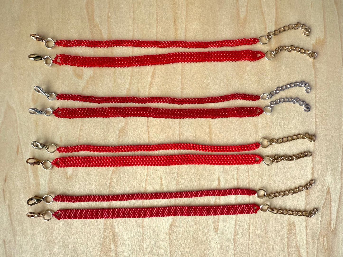 Red lanyards with metal clips on a wooden surface