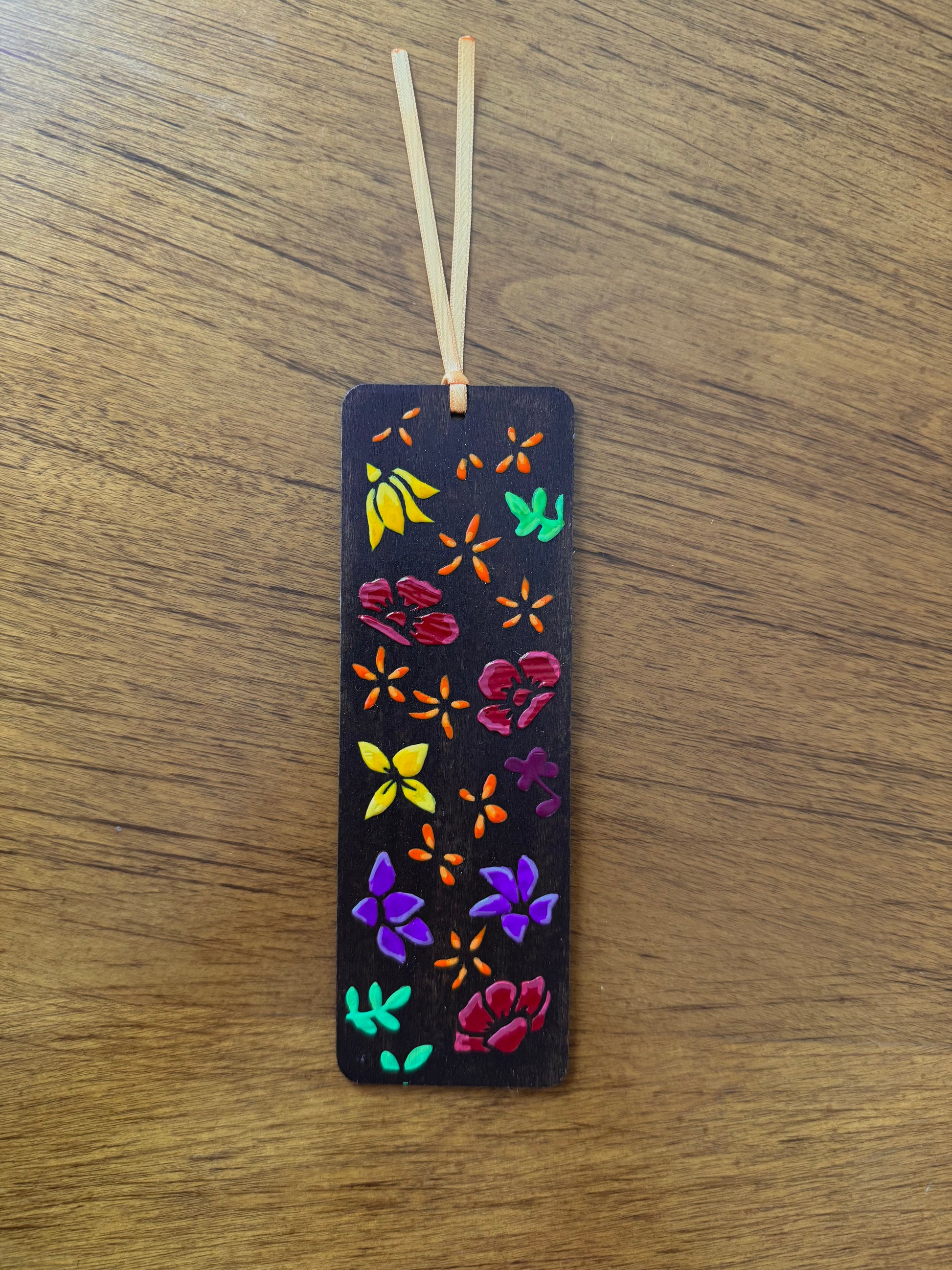 wooden bookmark with colorful floral patterns on a wooden surface