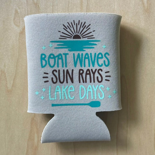 Gray can cooler with 'Boat Waves = Sun Rays = Lake Days' text on a wooden surface