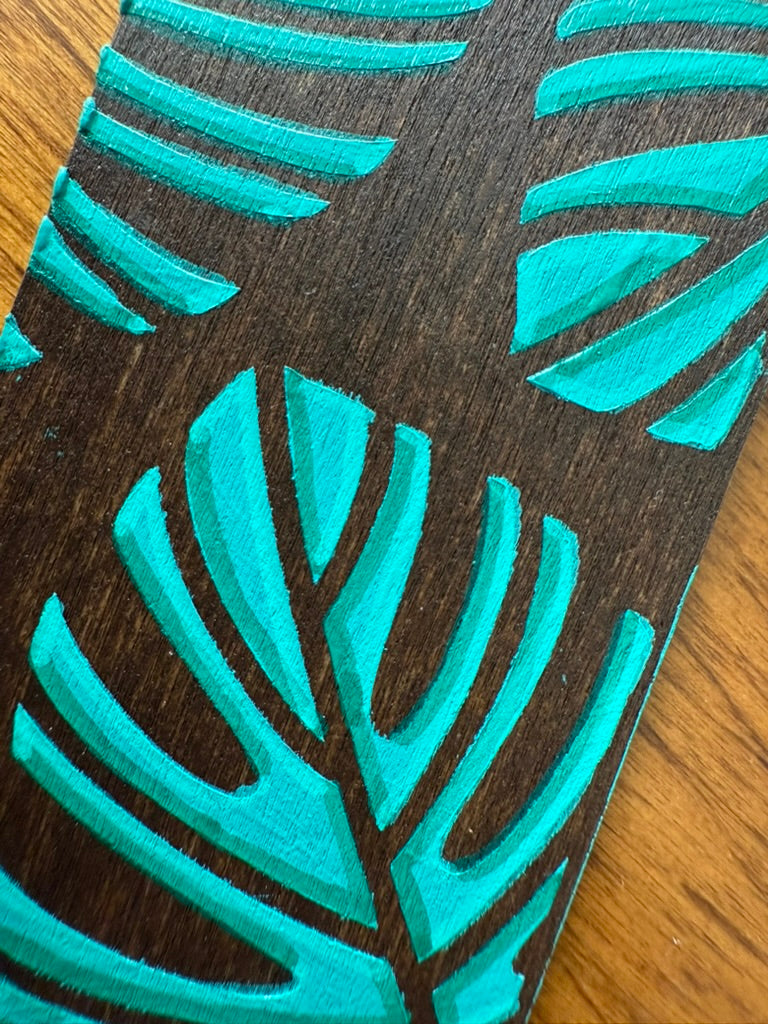 Teal leaf pattern on a wooden surface