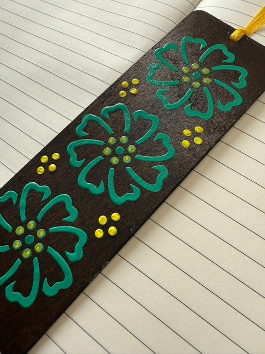 Decorative bookmark with green floral designs on a lined notebook page