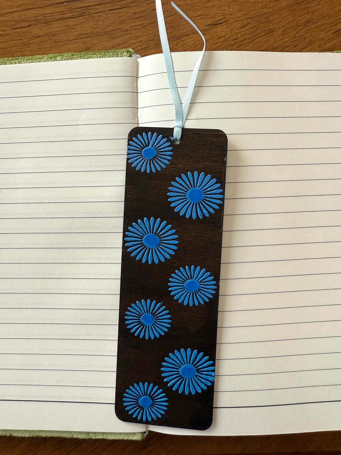 Bookmark with blue floral patterns on a wooden surface