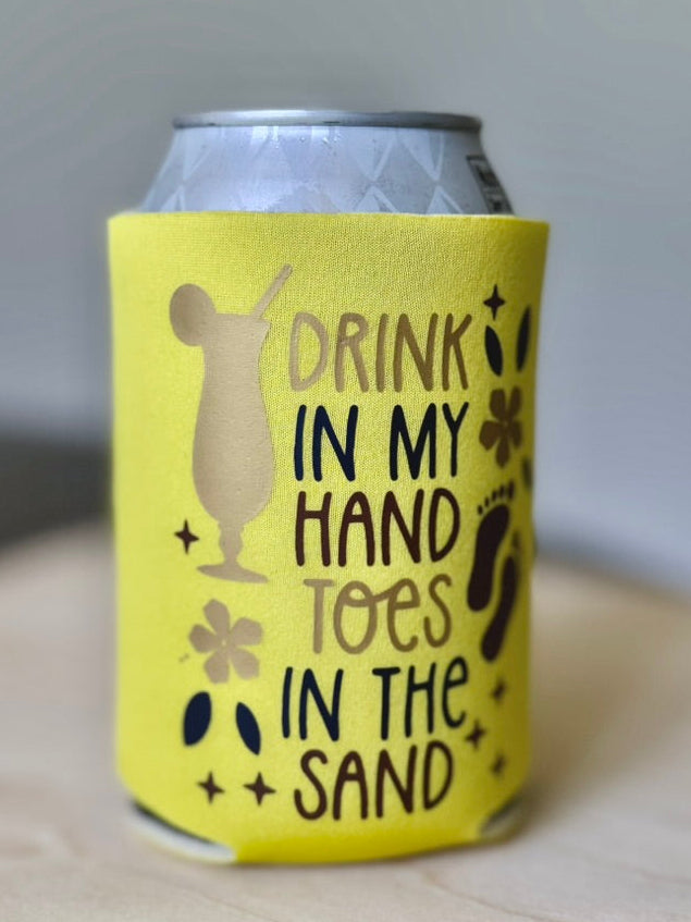 Yellow can cooler with beach-themed text on a wooden surface