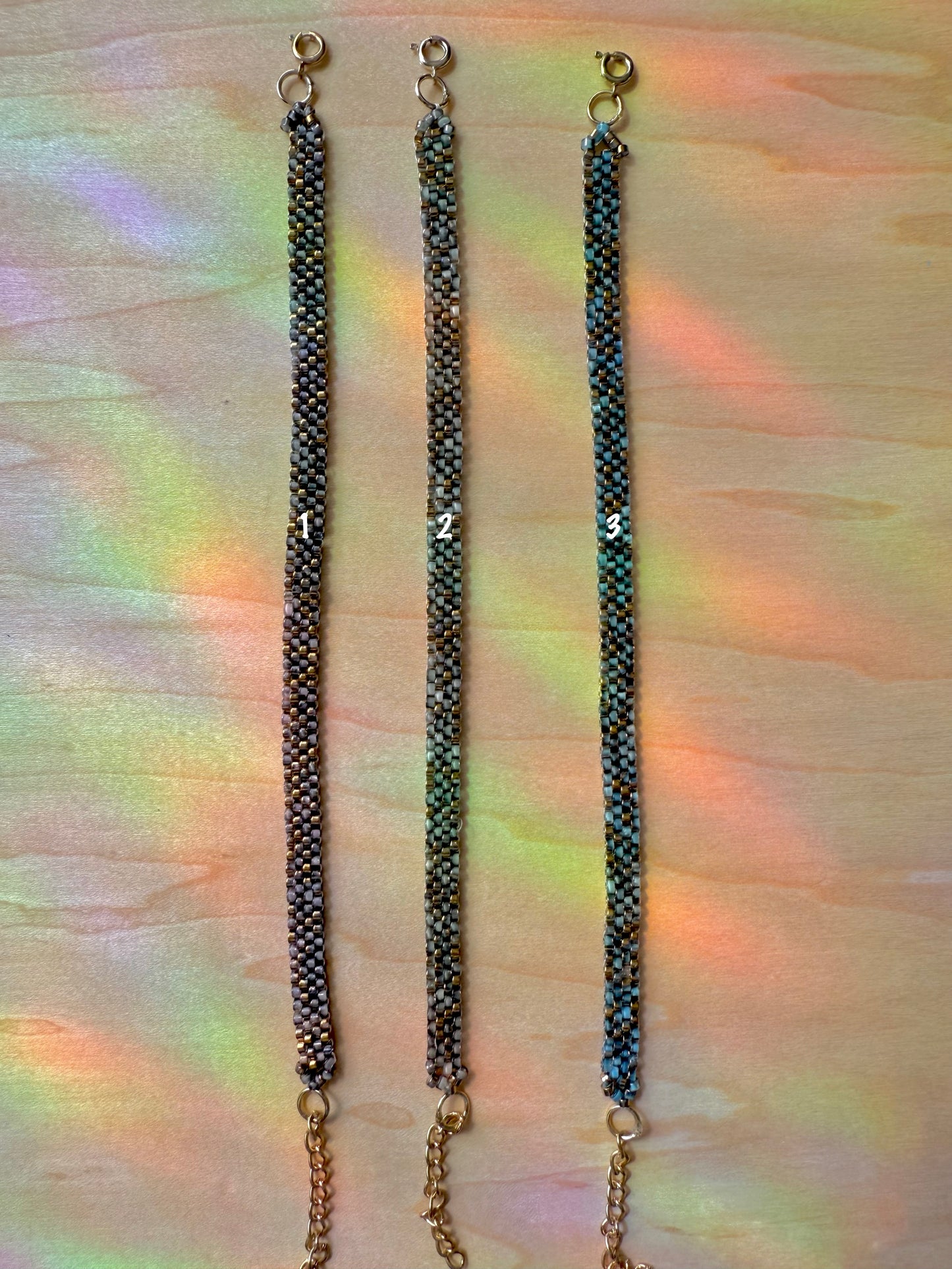 Three black beaded necklaces on a multicolored fabric background