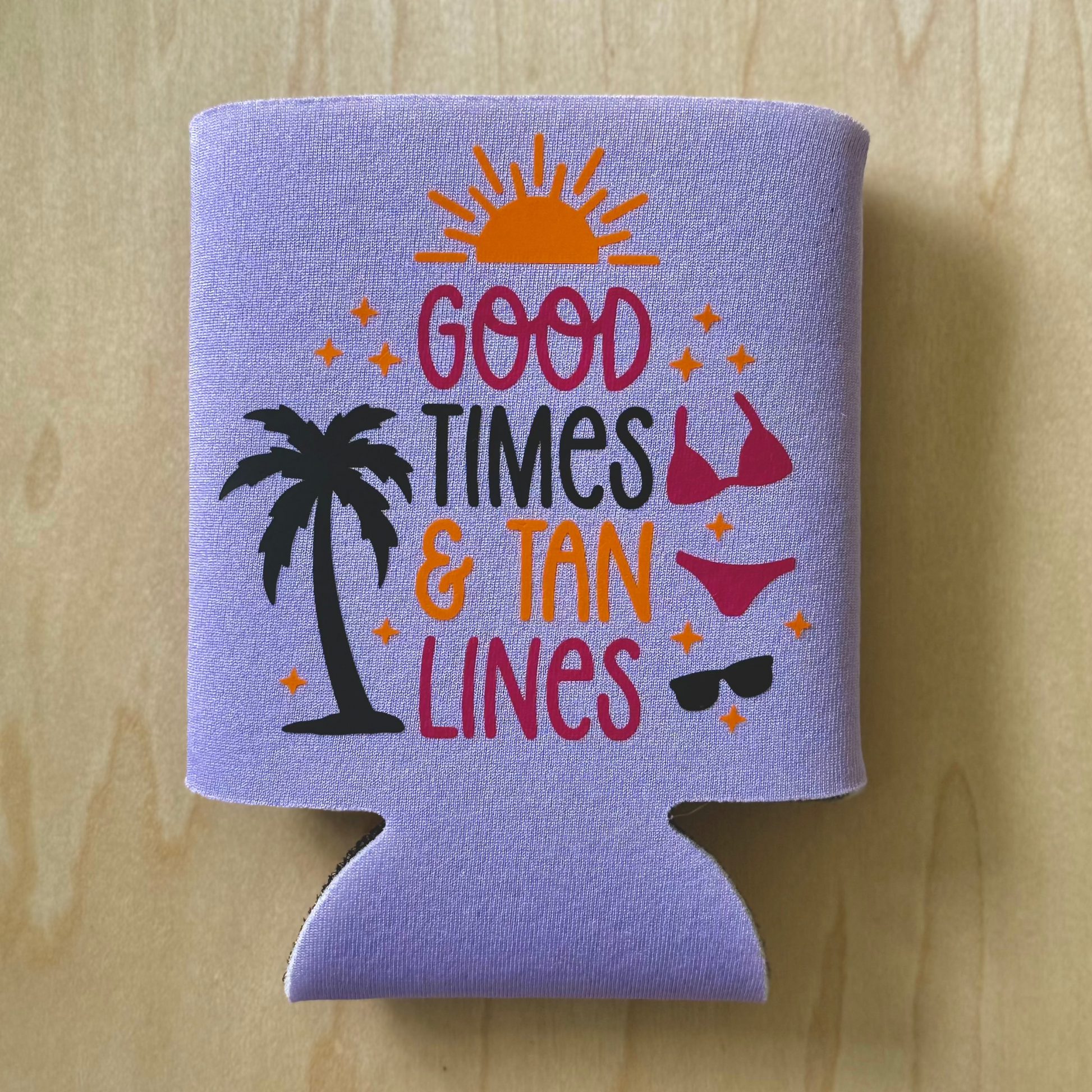 Purple can cooler with 'Good Times & Tan Lines' text and summer graphics on a wooden surface
